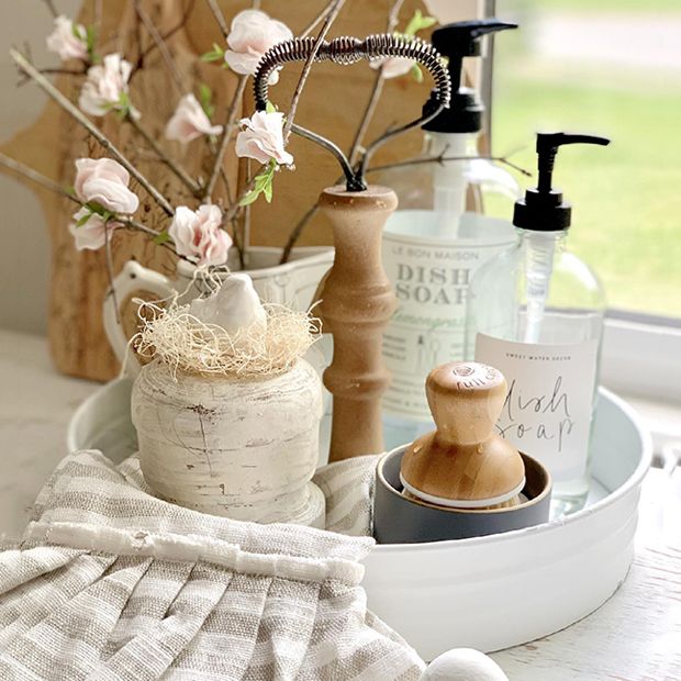 some bottles and soaps are sitting on a table next to a vase with flowers