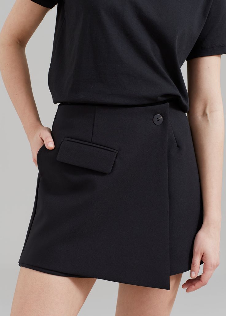 Color: Black Midweight suiting fabric Mini length A-line silhouette Shorts with skirt panel at front Single illusion front flap pocket Concealed back seam zip closure Asymmetric front button closure Partially lined 100% Polyester Dry Clean By The Frankie Shop. Imported Chic Asymmetrical Hem Bottoms For Work, Structured Black Bottoms For Workwear, Fitted Asymmetrical Office Bottoms, Fitted Asymmetrical Bottoms For Office, Structured Black Bottoms For Office, Formal Bottoms With Fitted Asymmetrical Hem, Elegant Asymmetrical Bottoms With Pockets, Modern Asymmetrical Skirt For Office, Formal Fitted Bottoms With Asymmetrical Hem