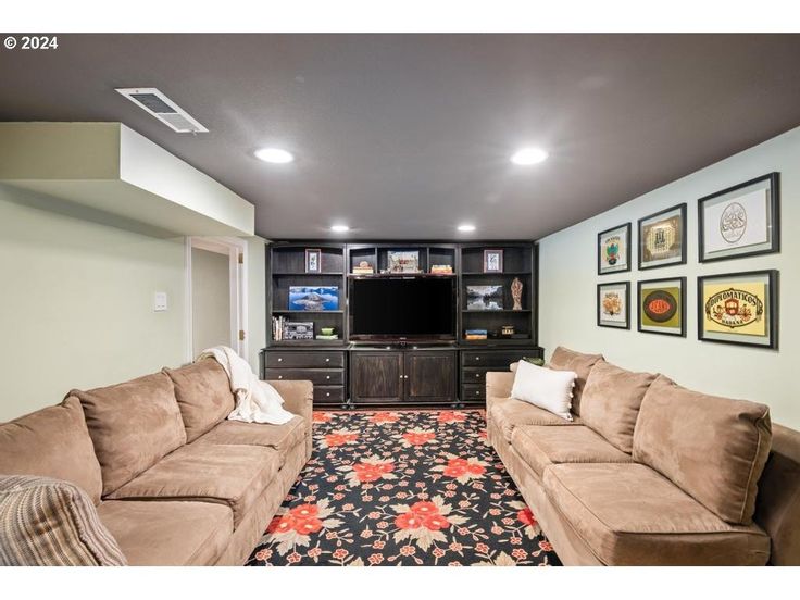 a living room with two couches and a flat screen tv on the wall in it