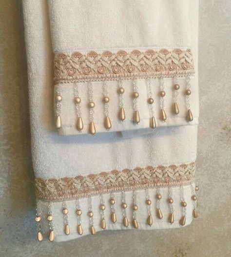 two white towels with beaded trim on them