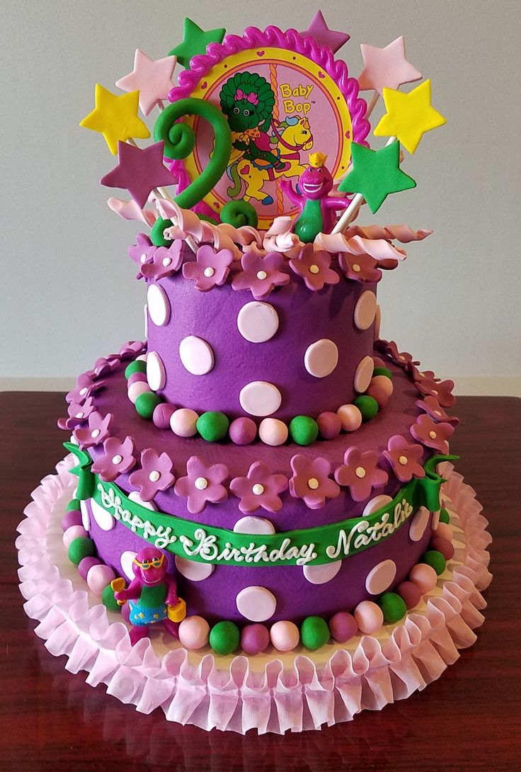 a birthday cake decorated with purple and green decorations