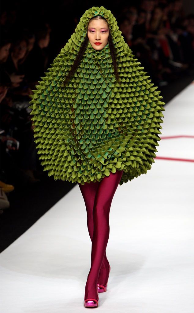 a woman is walking down the runway in a costume made out of leaves