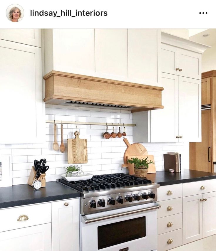 a kitchen with white cabinets and black counter tops is featured in the instagram post