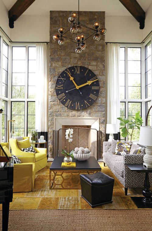 a living room filled with furniture and a large clock on the wall above a fireplace