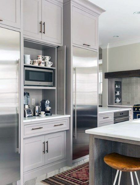 a large kitchen with stainless steel appliances and white counter tops, along with an area rug on the floor