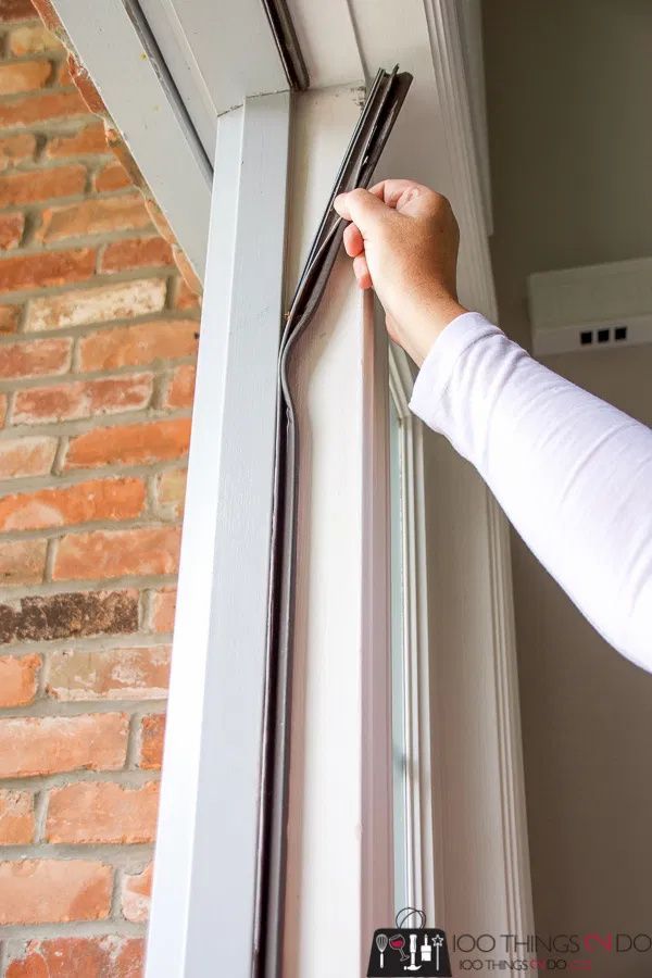 a person is holding onto the side of a window