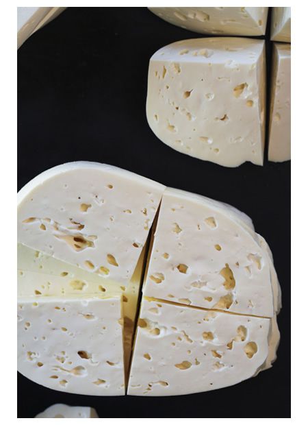 several pieces of cheese cut in half on a black surface