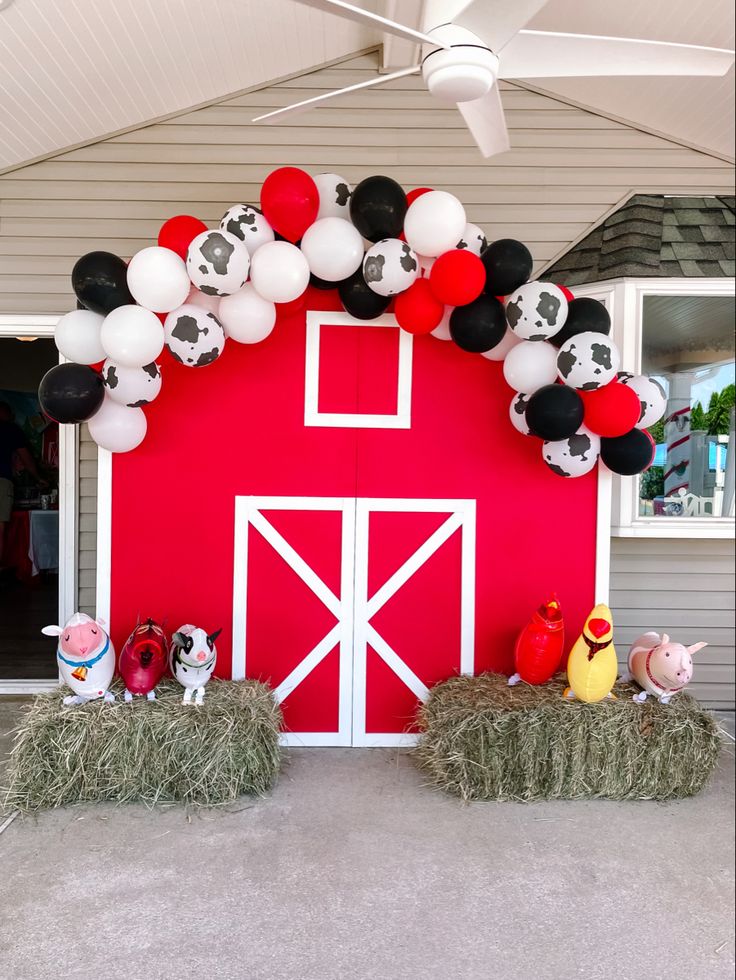 a red barn decorated with balloons and farm animals