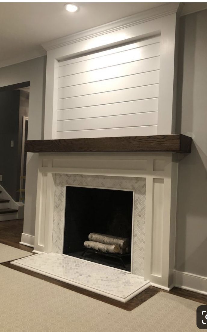 an empty living room with a fireplace and stairs