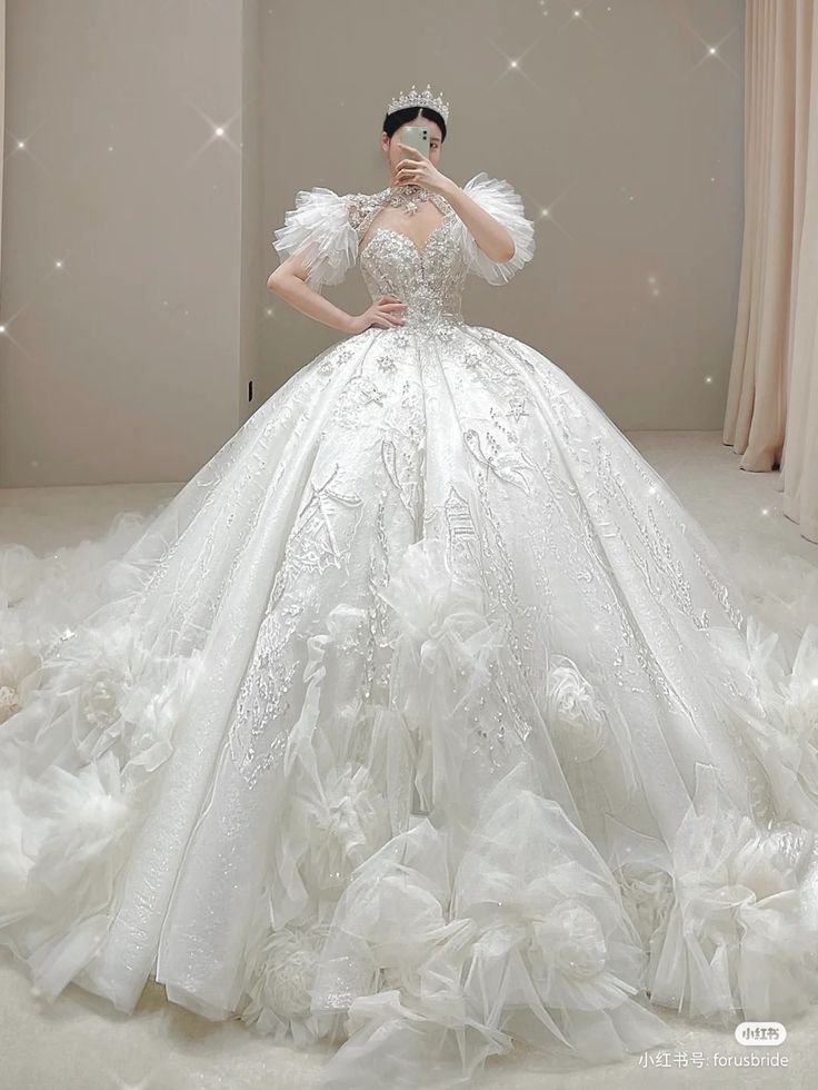 a woman in a white wedding dress standing on a bed of tulle and feathers