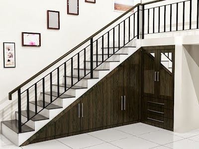 a stair case next to a set of stairs in a room with pictures on the wall