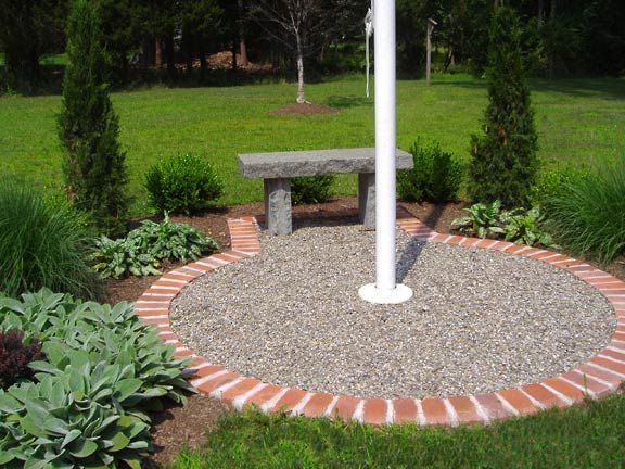 a stone bench sitting in the middle of a garden