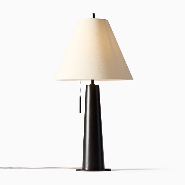 a black lamp with a white shade on it's side and a cord attached to the base