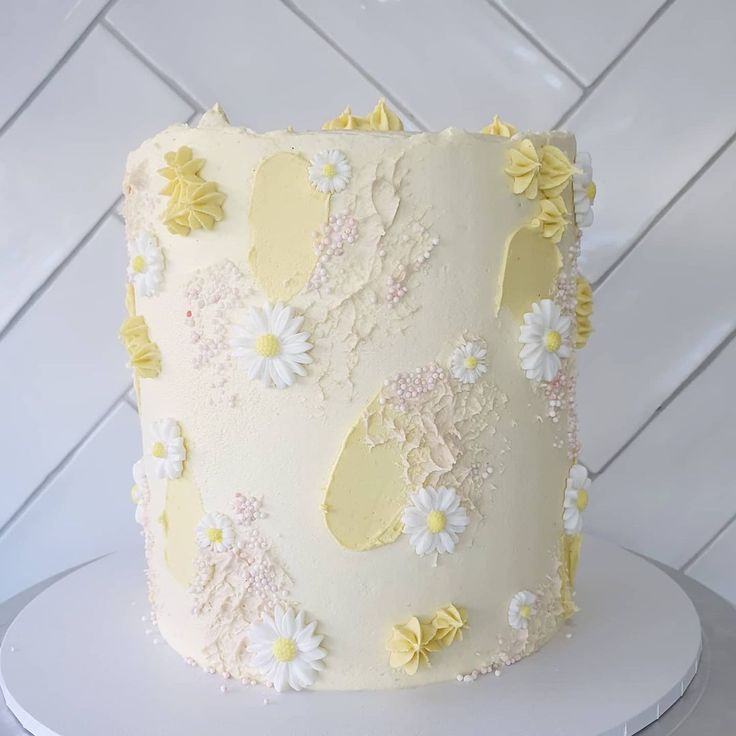 a white cake with yellow and white flowers on it