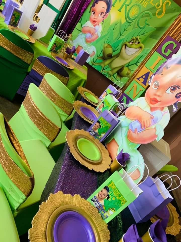 there is a table set up with green and purple decorations