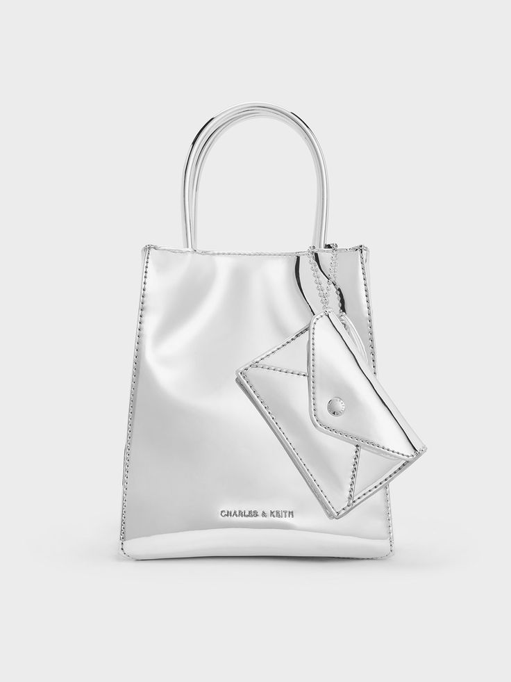 This item is part of our Online Exclusive selection, which consists of unique colourways and designs that are only available for purchase at CHARLESKEITH.COM.If you want to make a cool style statement, reach for this Matina tote bag in shiny silver. The classic elongated silhouette meets an impossible-to-miss mirrored finish to blend fashion and function. Equipped with a detachable cardholder for your smaller items, it is perfect for running errands or quick lunches during workdays. This stylish Chic Double Handle Bag For Gift, Trendy Satchel With Dust Bag For Gift, Trendy Double Handle Box Bag Gift, Trendy Double Handle Box Bag For Gift, Chic Double Handle Satchel As Gift, Gift Bucket Bag With Top Carry Handle, Trendy Double Handle Satchel As Gift, Modern Bucket Bag With Top Carry Handle For Gift, Luxury Everyday Gift Bag