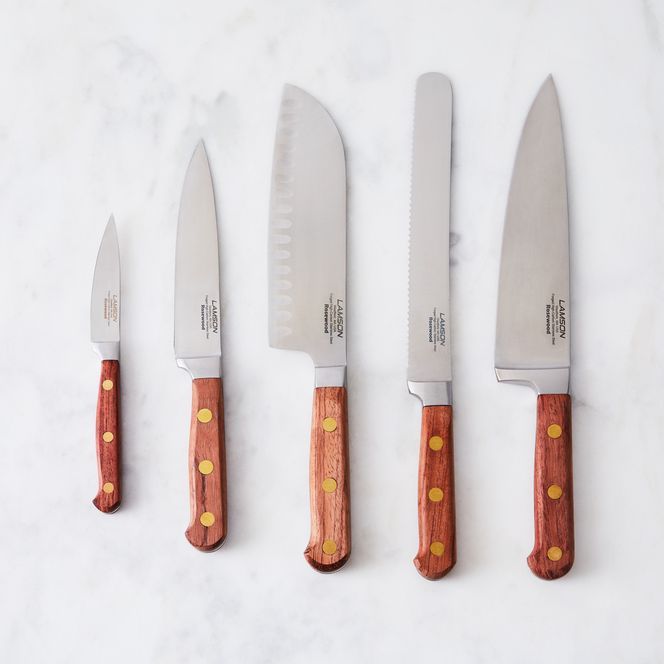 four knives are lined up next to each other on a white counter top with yellow dots