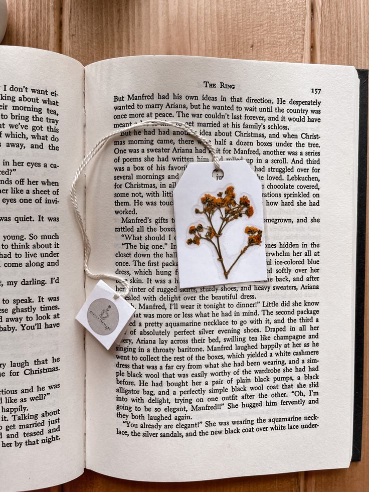 an open book with a flower on it and a rubber stamp attached to the page