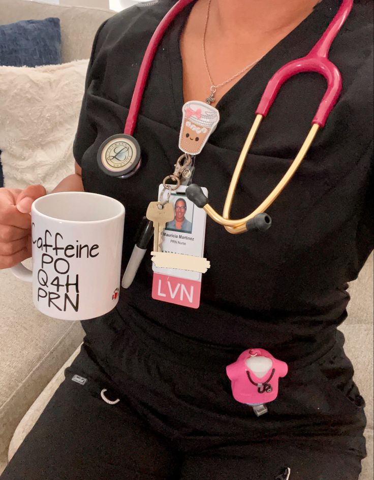 a woman in black shirt holding a coffee cup and nurse's stethoscope