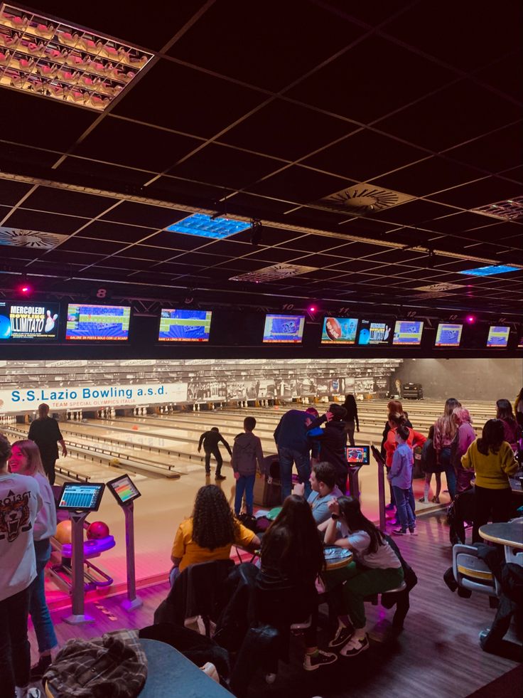 people are standing around at the bowling alley