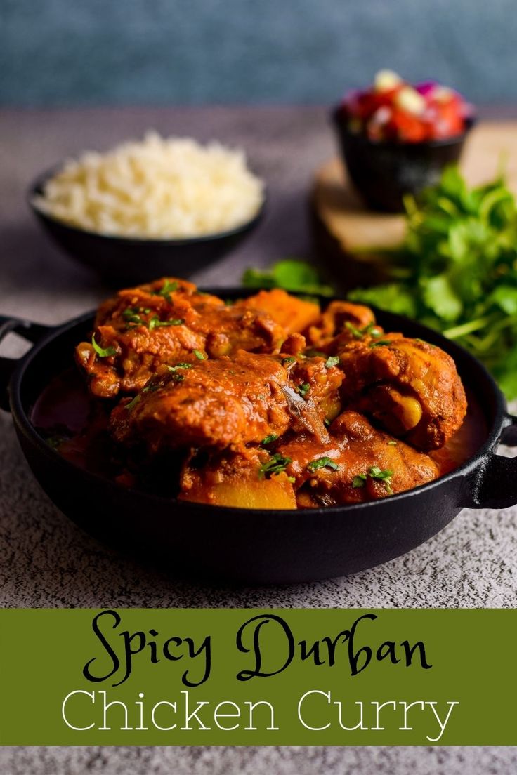 spicy durban chicken curry in a skillet with rice and cilantro