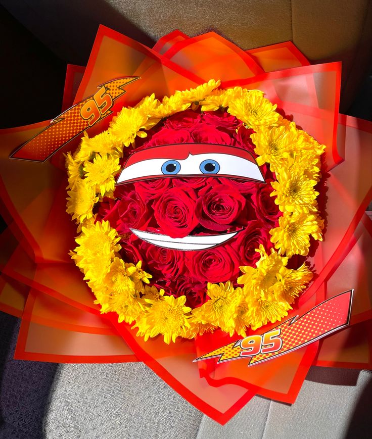 the sesame street bouquet is decorated with red roses and yellow flowers