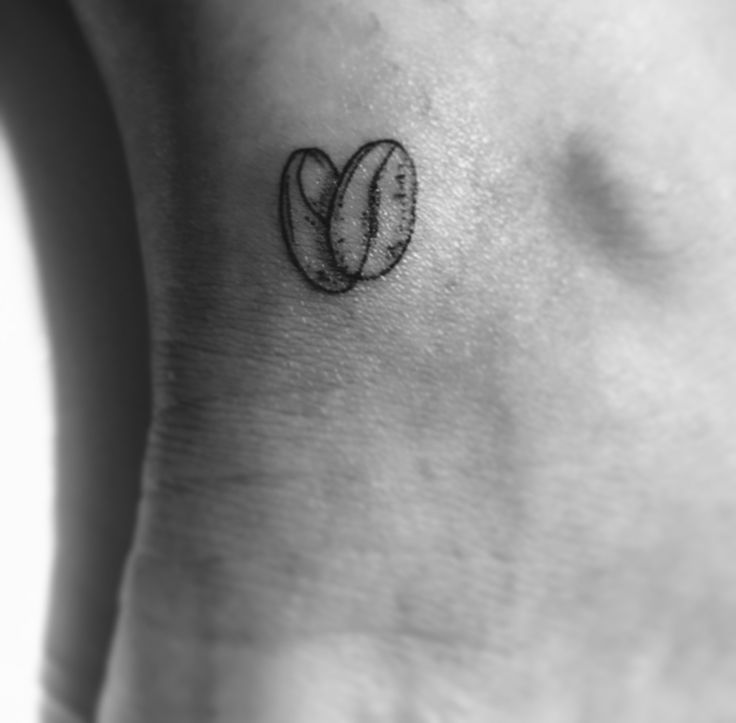 a black and white photo of a small tattoo on the side of a woman's ankle