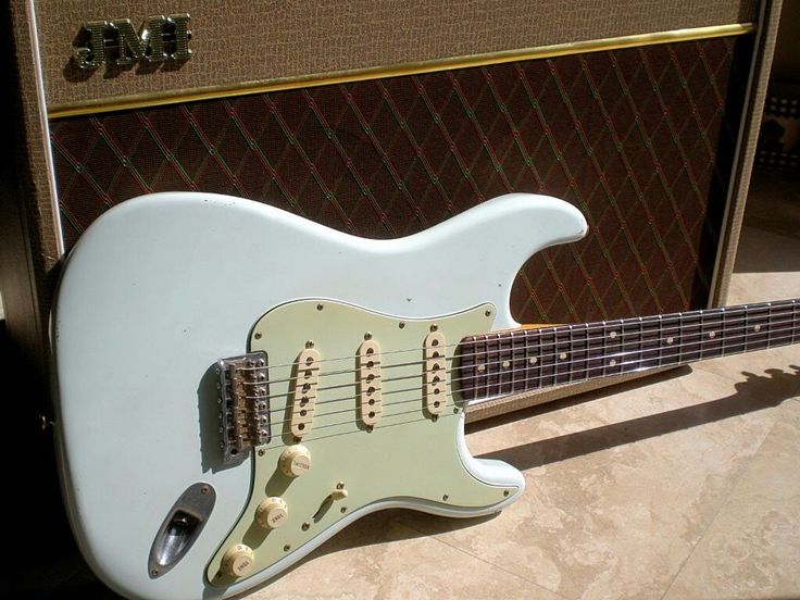 a white electric guitar sitting on top of a table