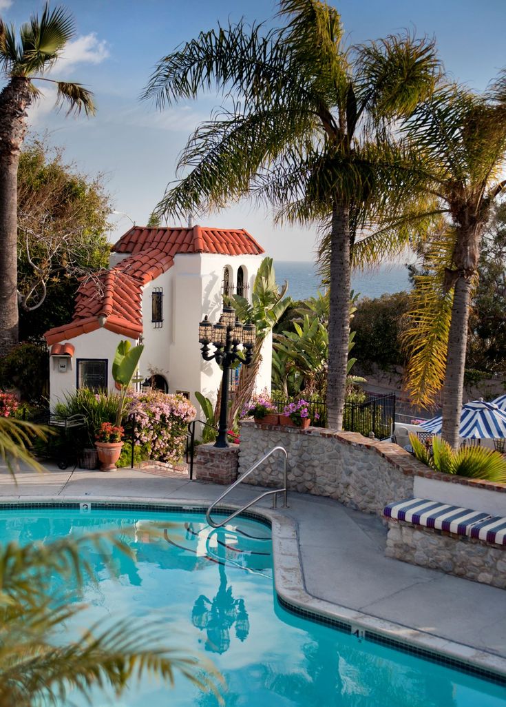 an outdoor swimming pool surrounded by palm trees