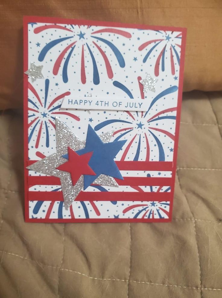 a red, white and blue fourth of july card on a quilted bed sheet