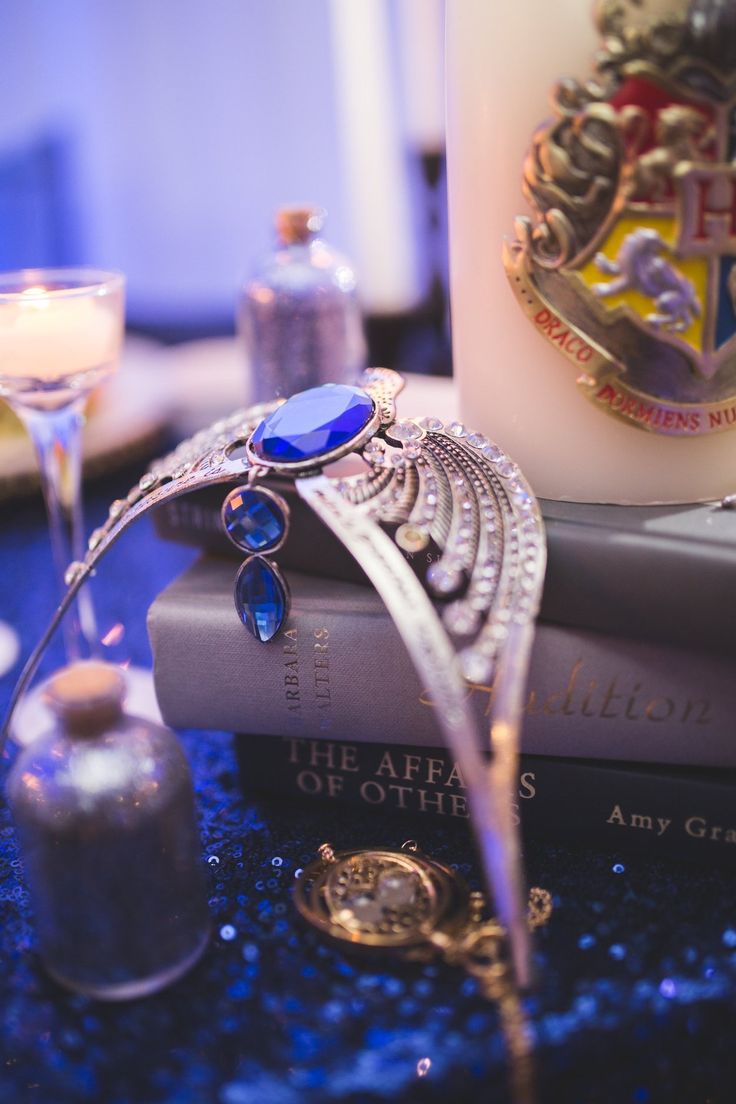 a stack of books sitting on top of a table next to a candle and some glasses