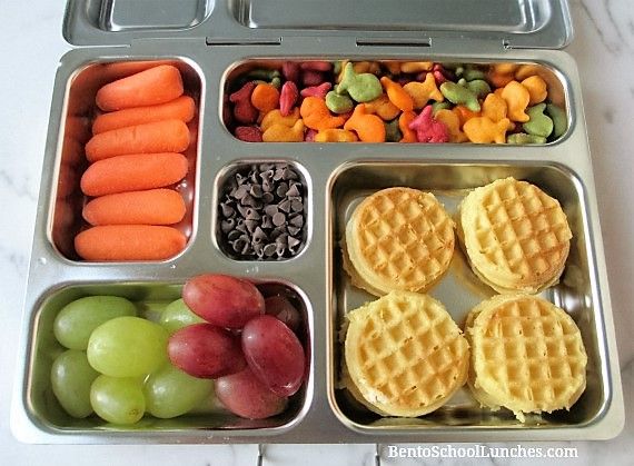 a lunch box filled with fruit, waffles and veggies on the side