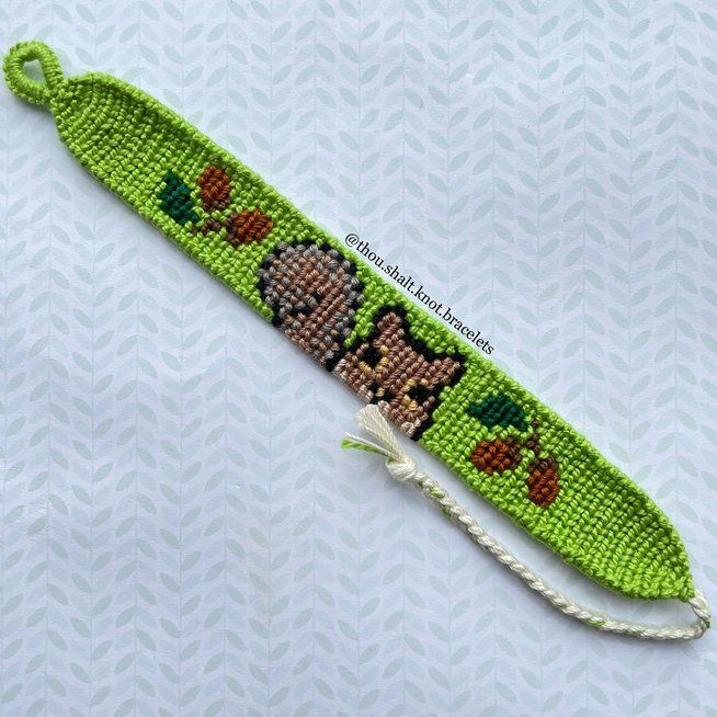 a green beaded bracelet with an image of a dog and apples on the side