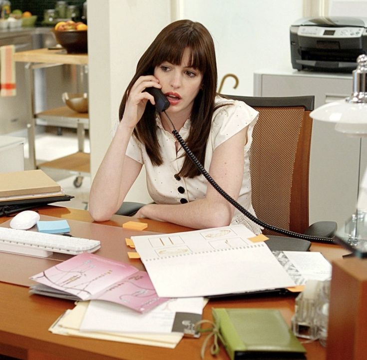 a woman sitting at a desk talking on the phone