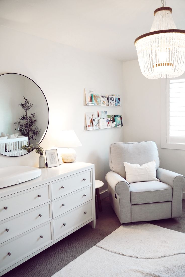 a bedroom with a chair, dresser and mirror