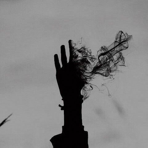 the silhouette of a person's hand reaching up into the air with their hair blowing in the wind