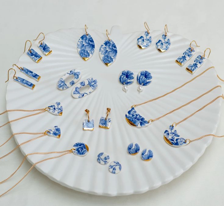 a white plate topped with lots of blue and gold necklaces on top of it