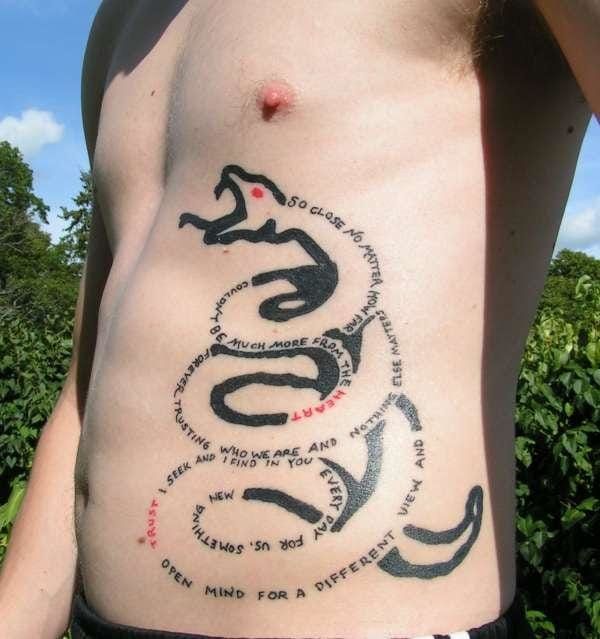 a person with a tattoo on their stomach that has words written all over the side