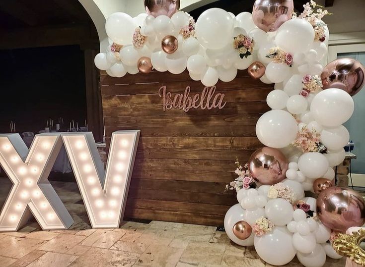 the balloon arch is decorated with white and gold balloons