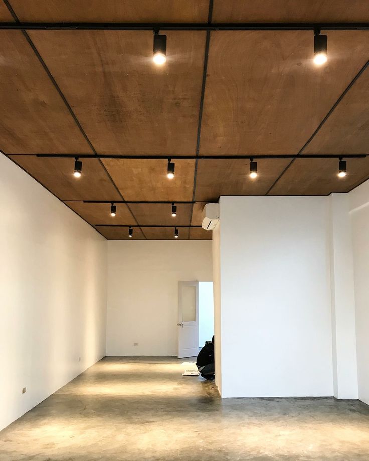 an empty room with white walls and ceiling lights