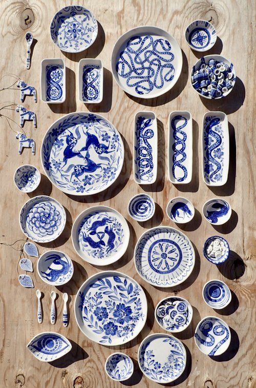 blue and white dishes are laid out on a wooden table