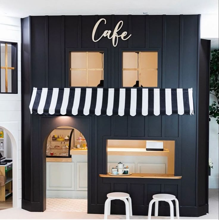 the interior of a cafe with black walls and white awnings