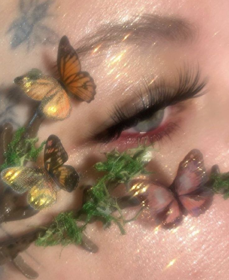 a woman's face with butterflies painted on her cheek and eyes, all around her