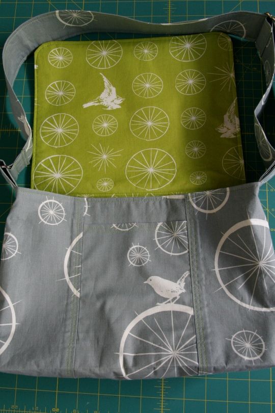 a green and white bag sitting on top of a table next to a cutting board