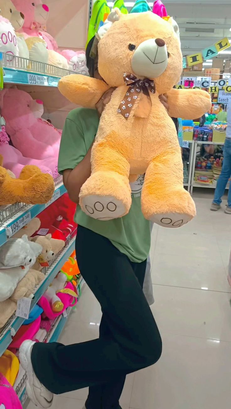 a person holding a large teddy bear in a store