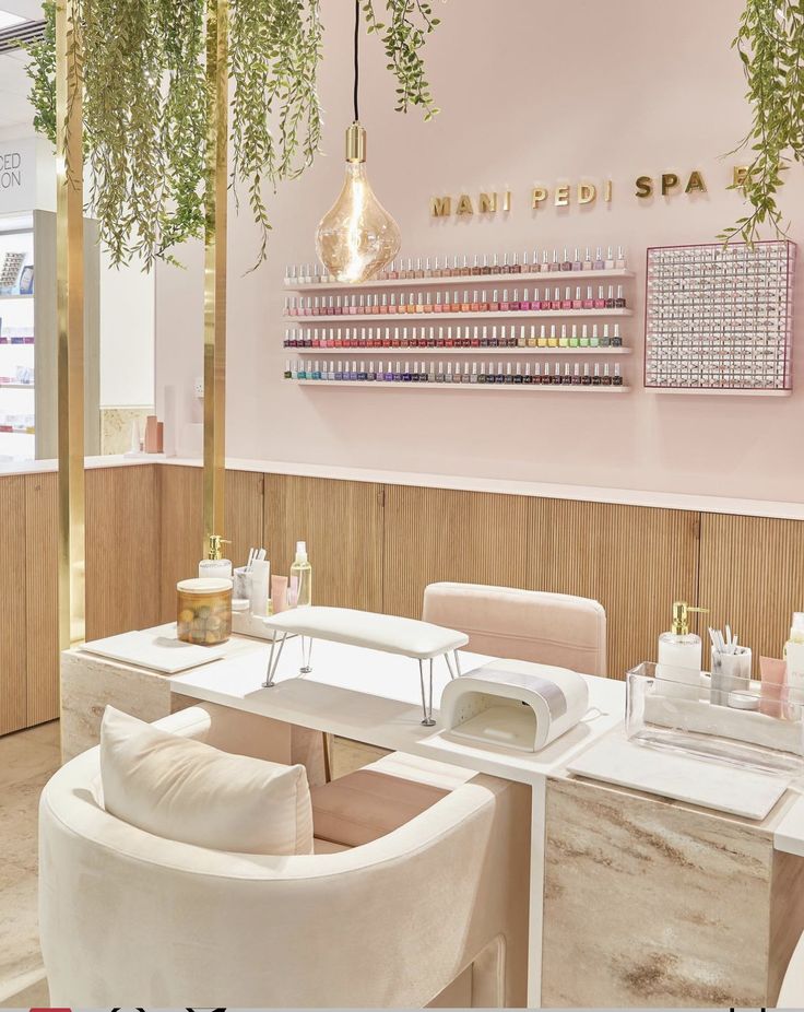 the inside of a nail salon with pink walls and white chairs, plants hanging from the ceiling