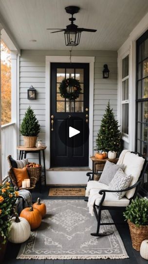 a porch decorated for fall with pumpkins and potted trees