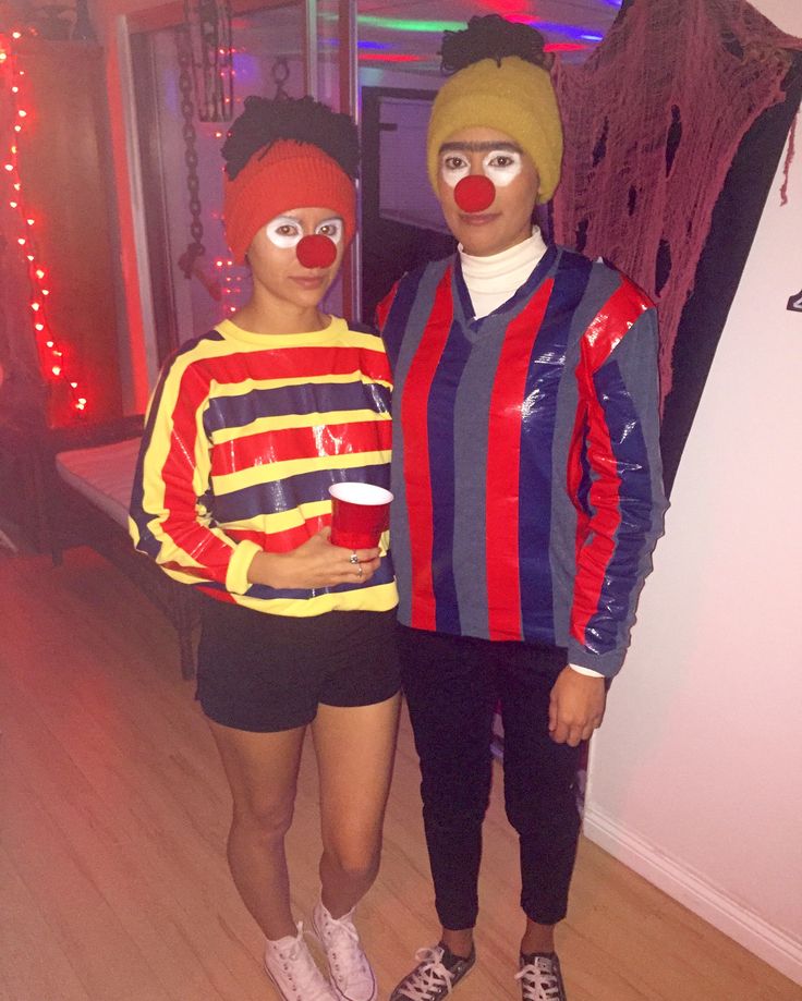 two people dressed up as clowns standing next to each other