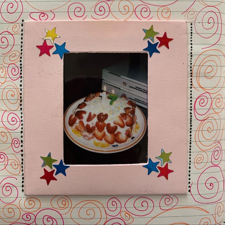 a pink frame holds a cake with hearts and stars on it