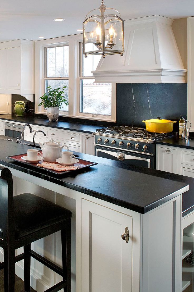 a kitchen with black counter tops and white cabinets